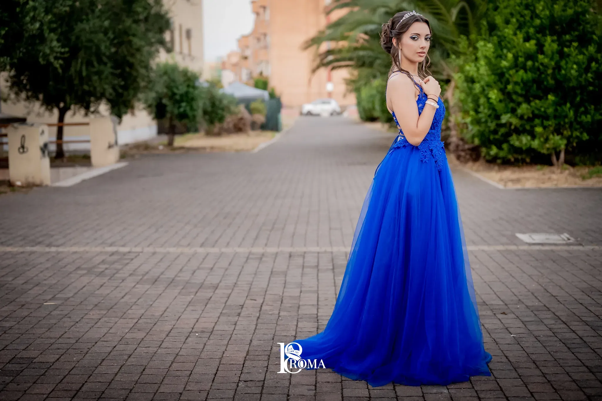 Ragazza in abito blu lungo una strada al tramonto